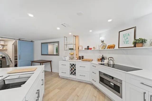 a kitchen with sink white cabinets and stove