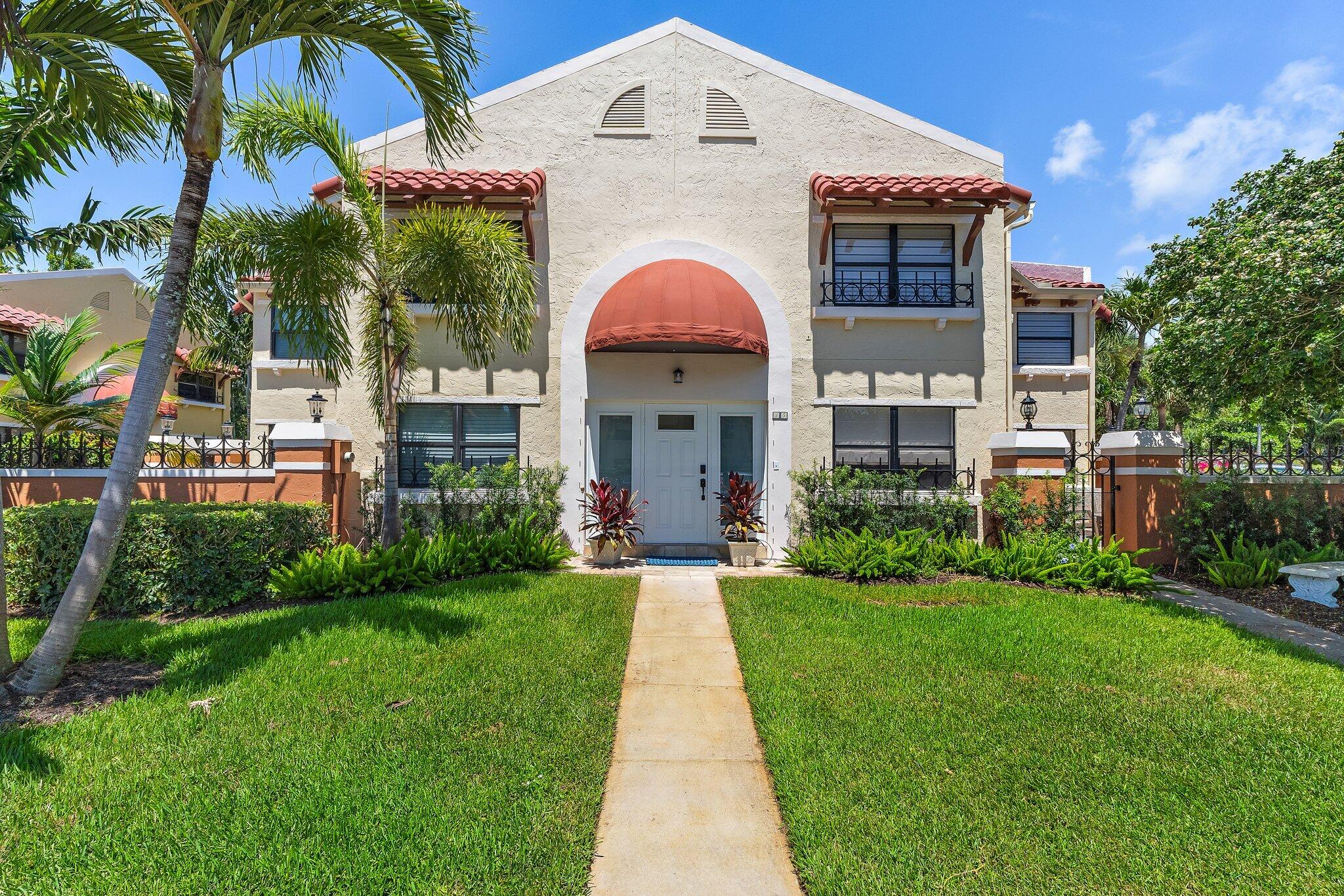 15 Uno Lago Drive, Unit 15 Juno Beach, FL 33408 - Photo 2 of 50 a front view of a house with a garden and plants