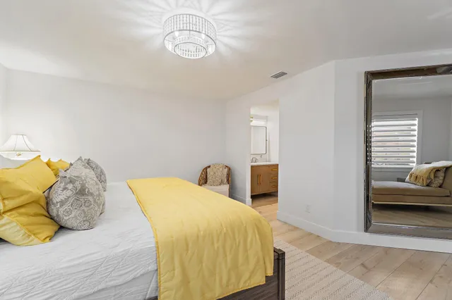 a bedroom with a bed and a chandelier