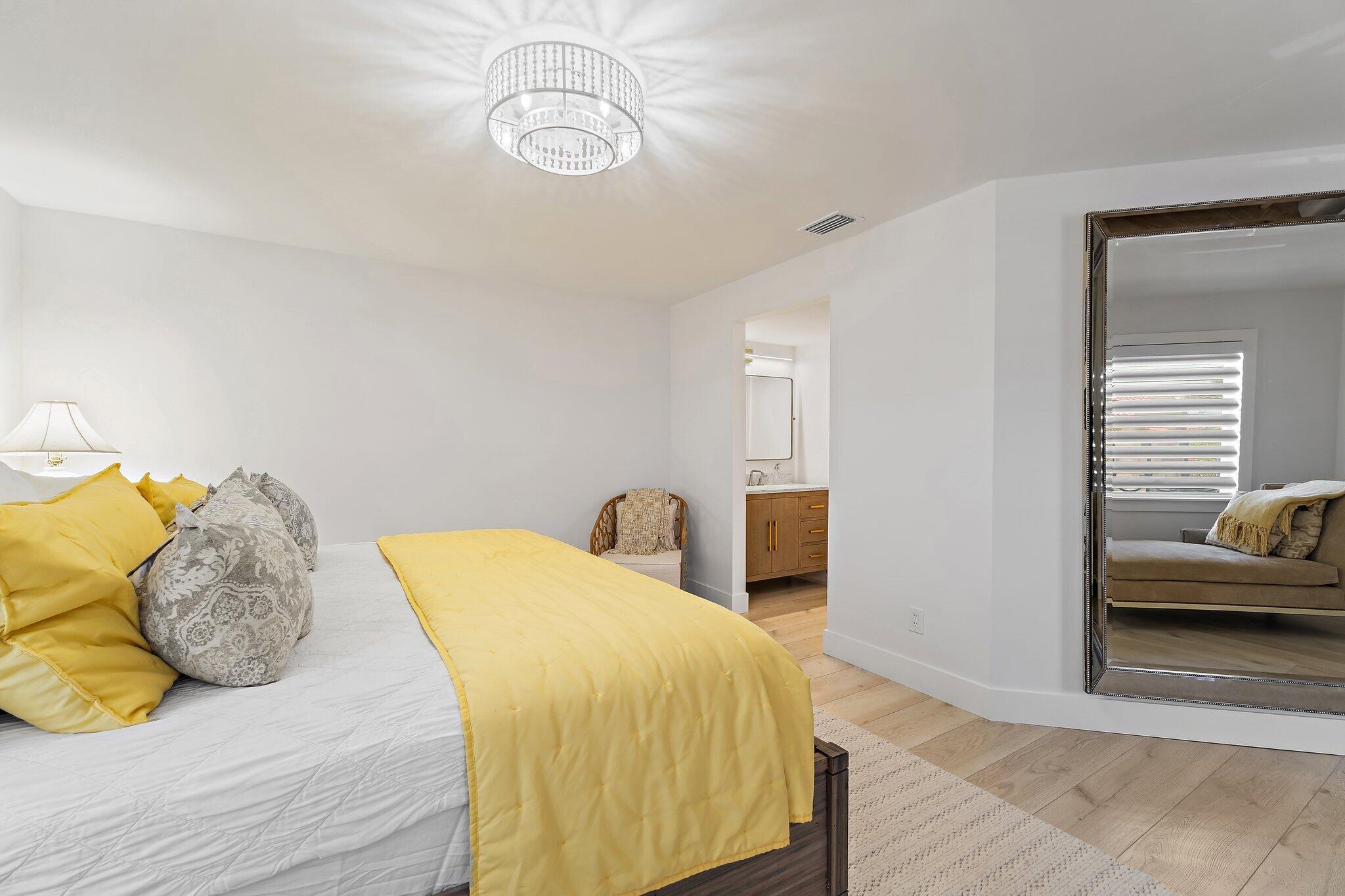 15 Uno Lago Drive, Unit 15 Juno Beach, FL 33408 - Photo 26 of 50 a bedroom with a bed and a chandelier