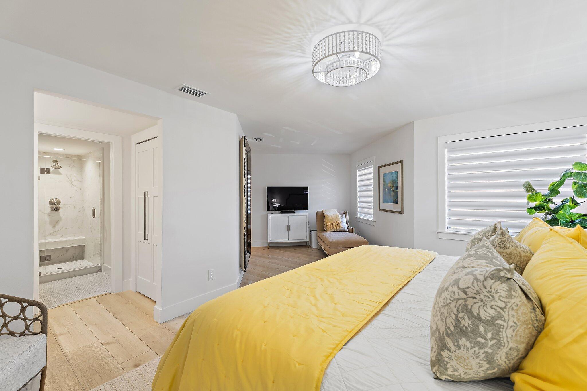 15 Uno Lago Drive, Unit 15 Juno Beach, FL 33408 - Photo 27 of 50 a bedroom with a bed and a chandelier