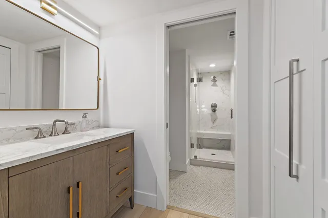 a bathroom with a granite countertop sink and a mirror