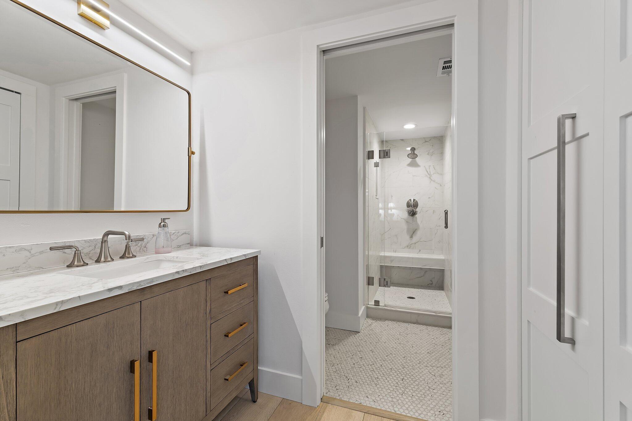 15 Uno Lago Drive, Unit 15 Juno Beach, FL 33408 - Photo 28 of 50 a bathroom with a granite countertop sink and a mirror