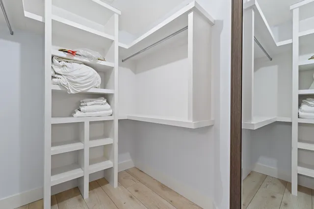 a view of walk in closet with clothes and shoes