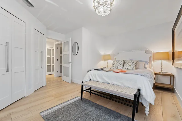 a spacious bedroom with a bed and a chandelier