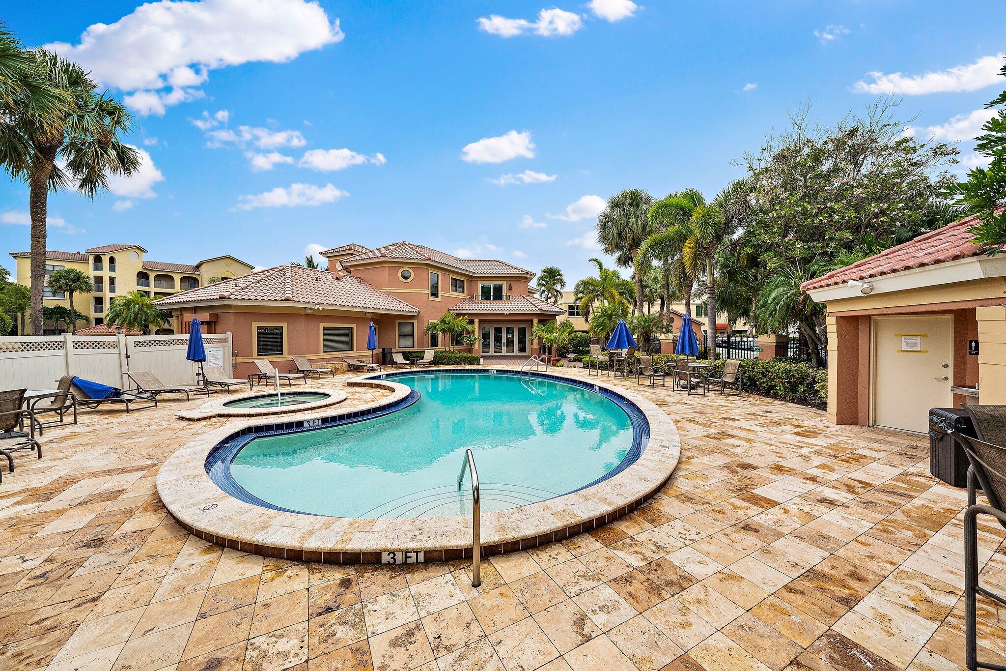 15 Uno Lago Drive, Unit 15 Juno Beach, FL 33408 - Photo 40 of 50 a view of a swimming pool with a lounge chairs