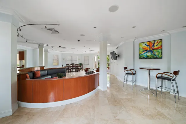a view of a kitchen with kitchen island stainless steel appliances a stove a table and chairs