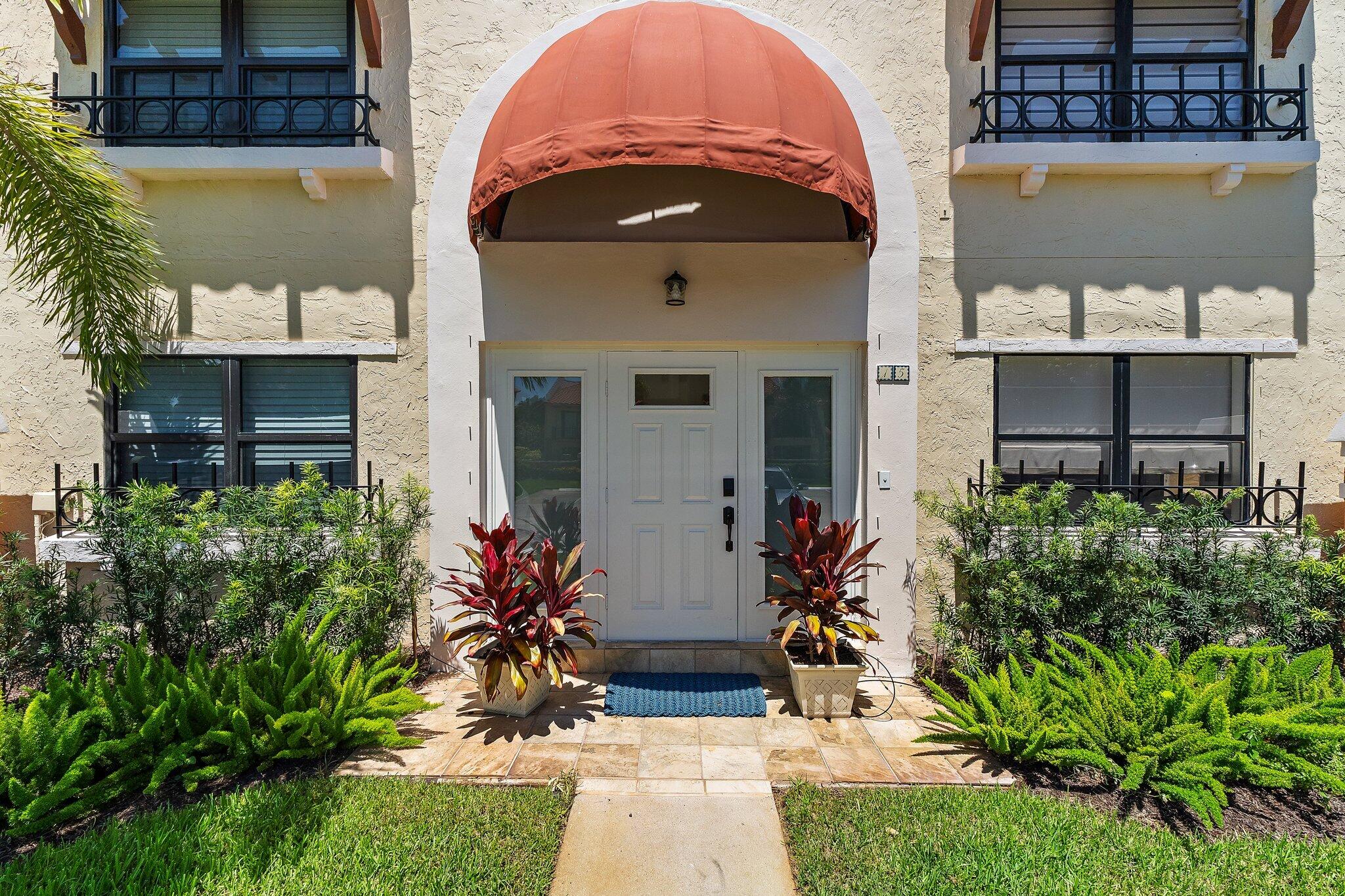 15 Uno Lago Drive, Unit 15 Juno Beach, FL 33408 - Photo 5 of 50 a front view of a house with a yard
