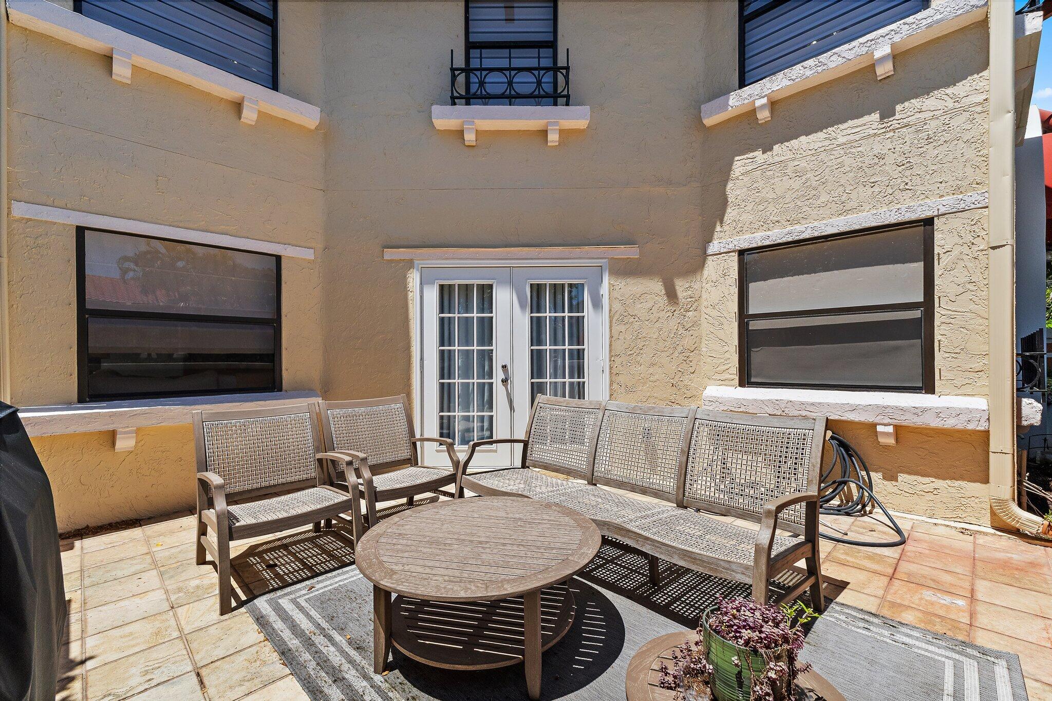 15 Uno Lago Drive, Unit 15 Juno Beach, FL 33408 - Photo 7 of 50 a outdoor space with patio furniture and a fireplace