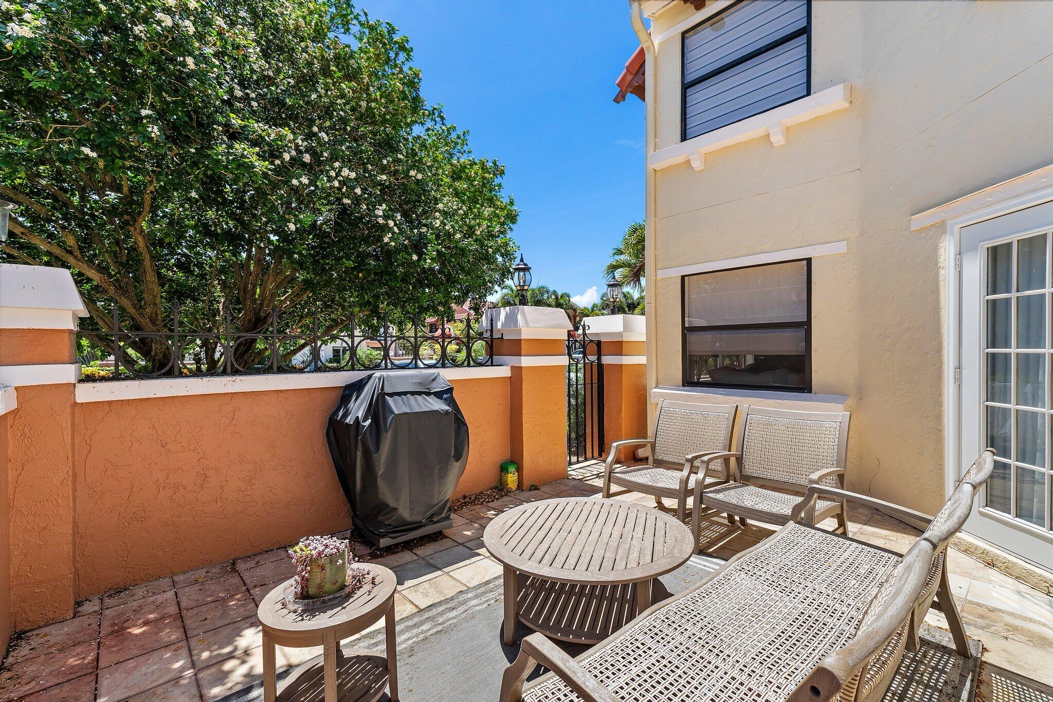 15 Uno Lago Drive, Unit 15 Juno Beach, FL 33408 - Photo 8 of 50 a view of a patio with a dining table and chairs