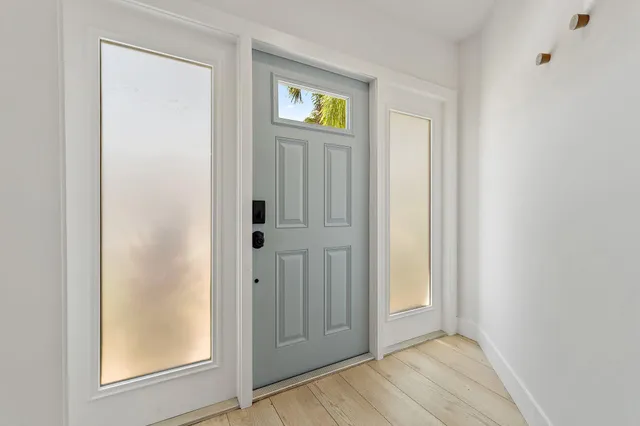 an empty room with wooden floor closet and windows