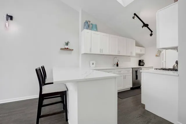a kitchen with cabinets appliances a sink and a counter