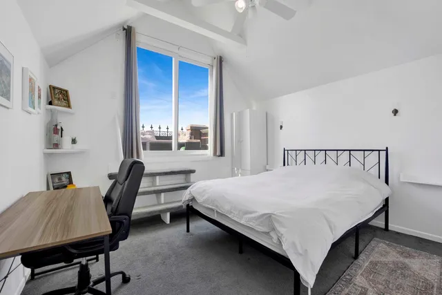 a bedroom with a bed a desk and chair