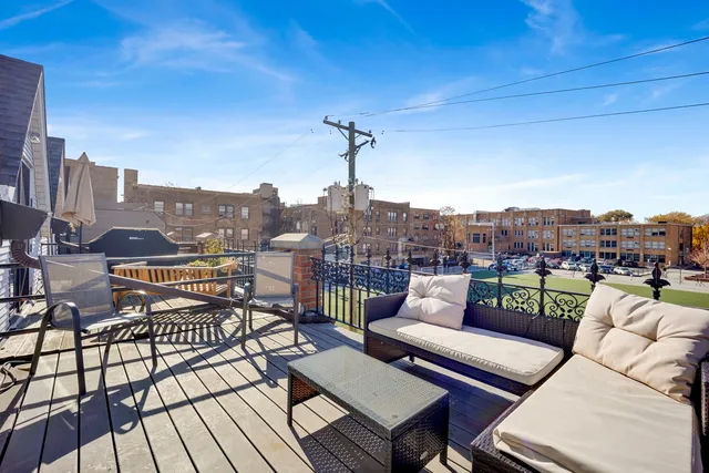 a view of a rooftop deck with couch and chairs