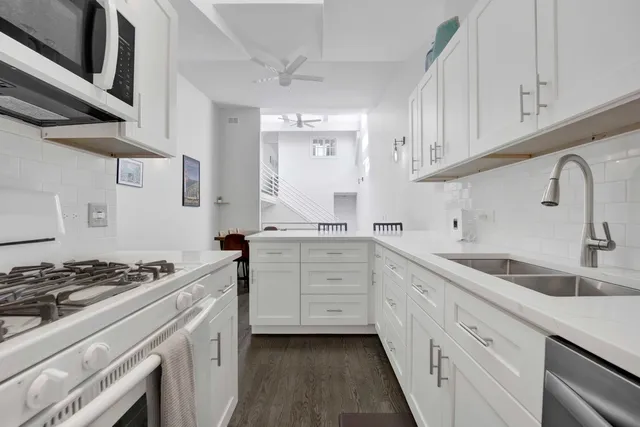 a kitchen with granite countertop a sink stove and cabinets