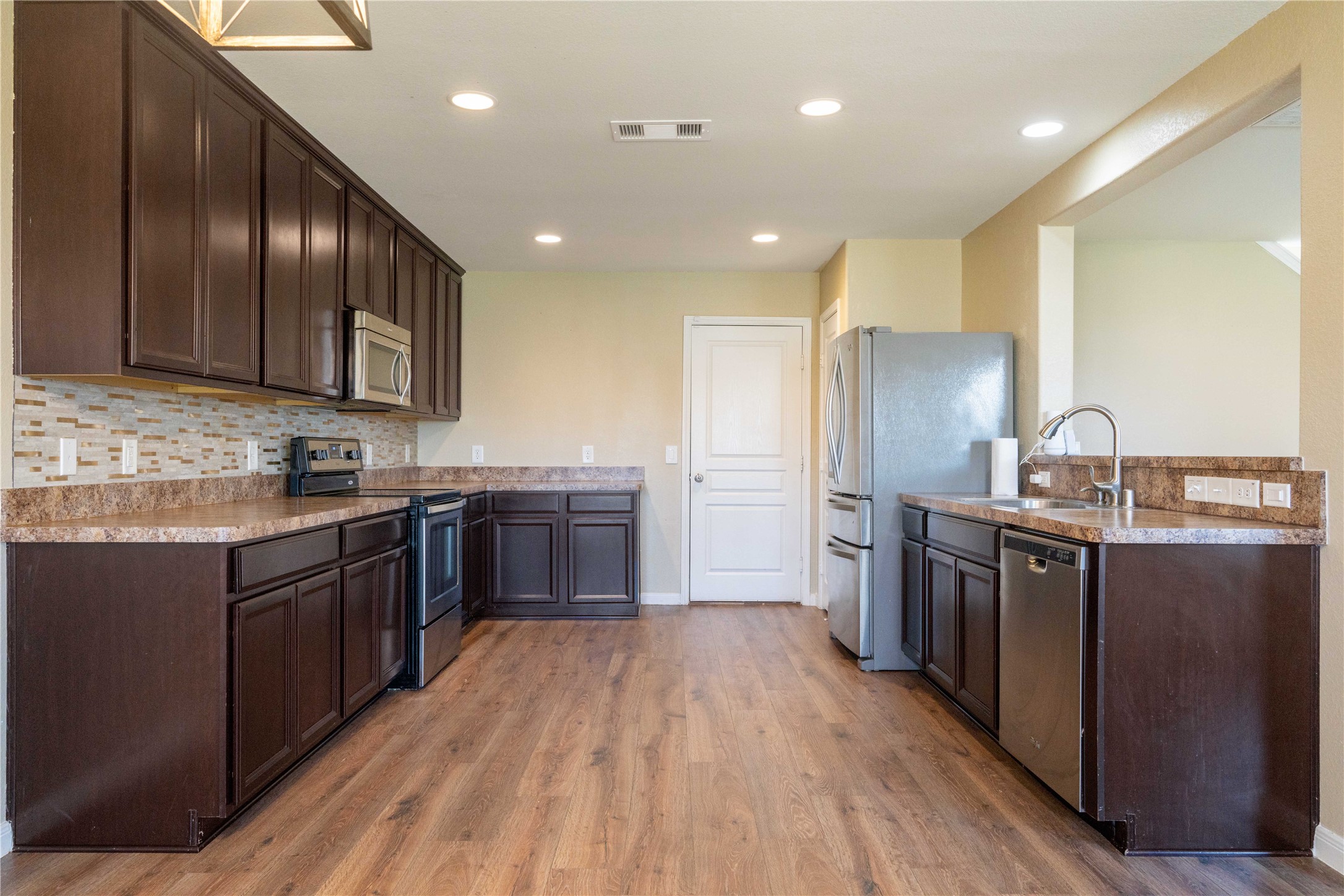10011 Orchid Spring Lane Houston, TX 77044 - Photo 17 of 42 a kitchen with stainless steel appliances granite countertop wooden cabinets a sink dishwasher a stove and a refrigerator
