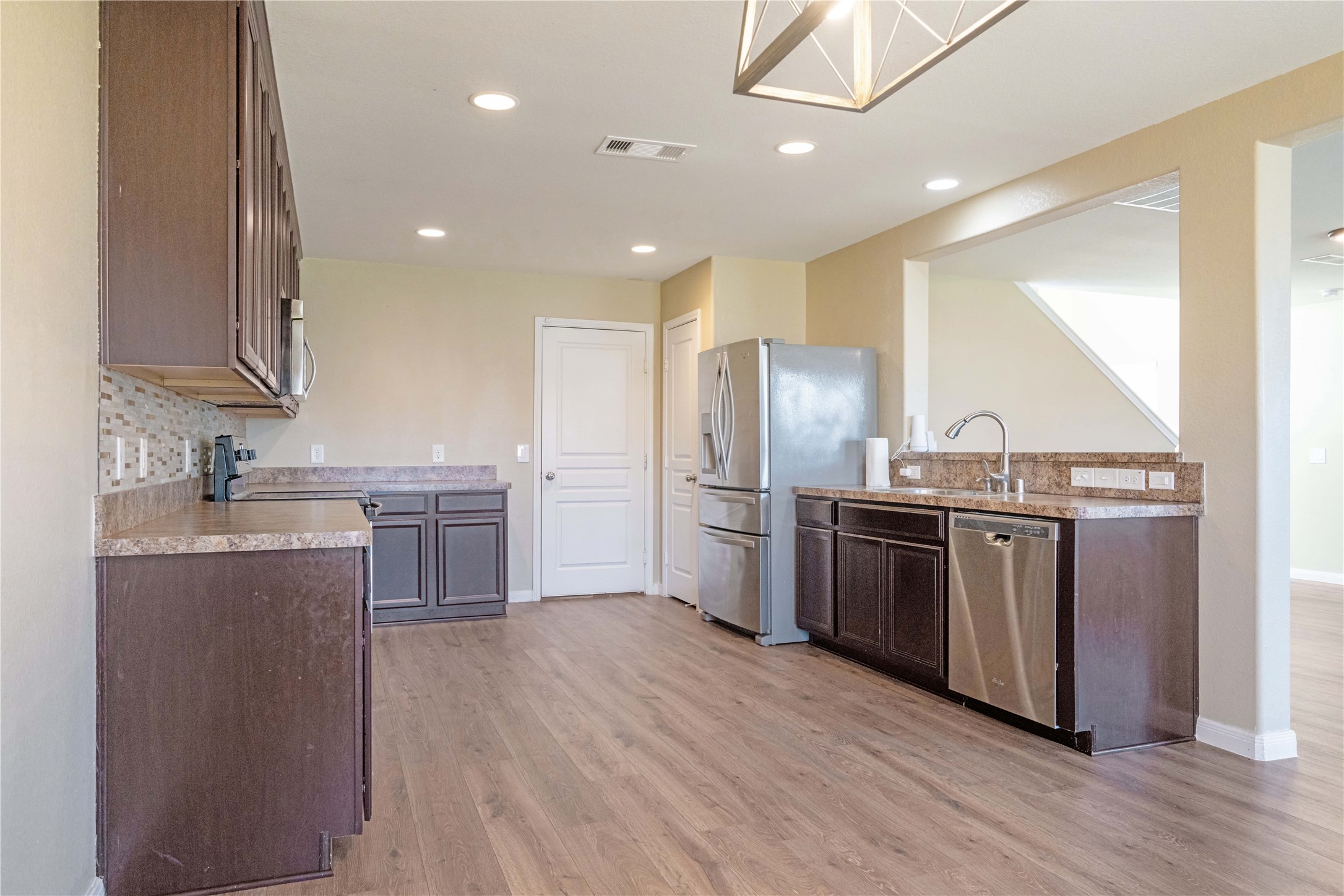10011 Orchid Spring Lane Houston, TX 77044 - Photo 19 of 42 a kitchen with stainless steel appliances granite countertop a refrigerator a sink dishwasher a stove and a microwave oven with wooden floor