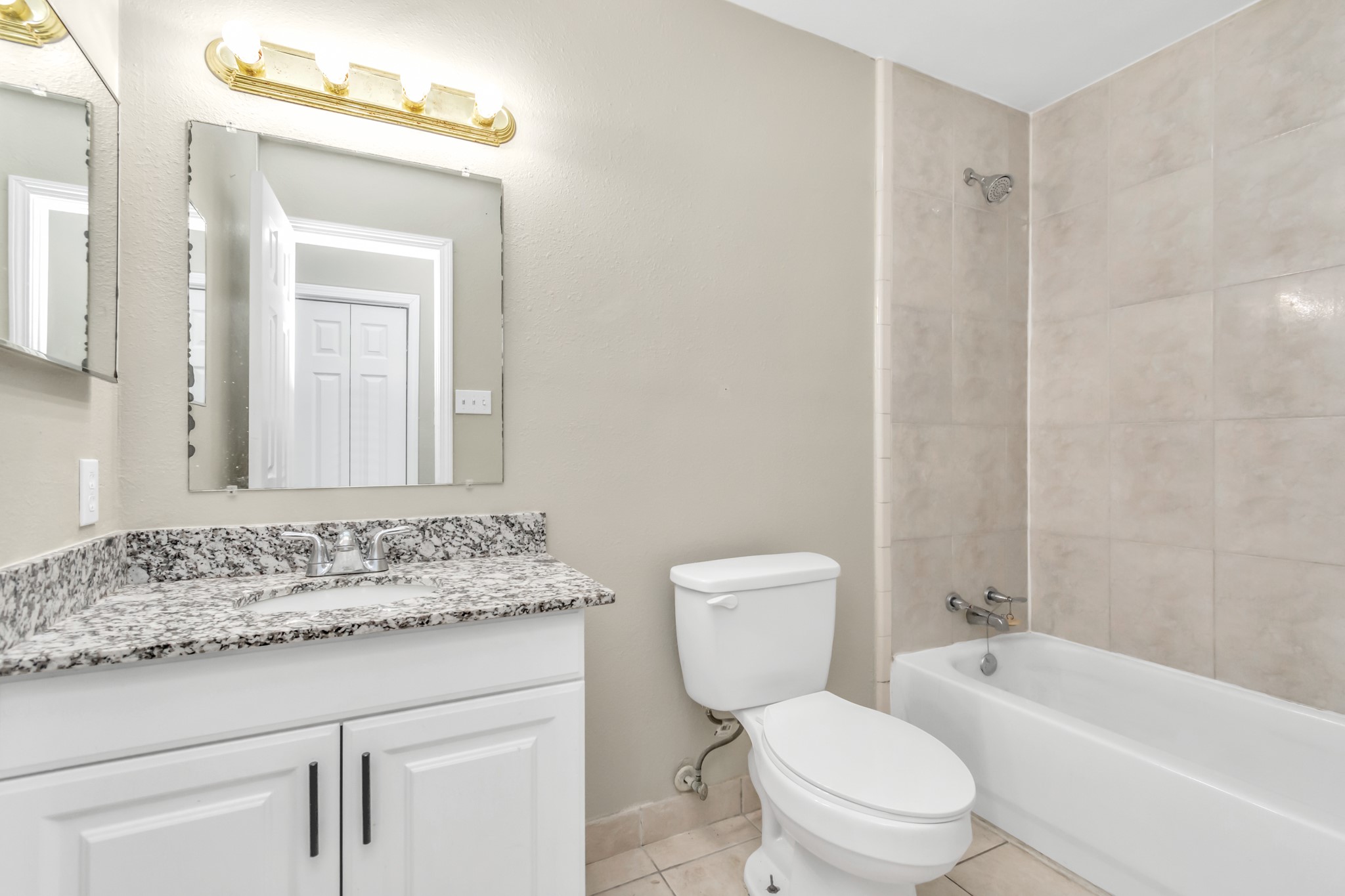 14519 Edenglen Drive Houston, TX 77049 - Photo 24 of 32 a bathroom with a granite countertop toilet a sink and a mirror