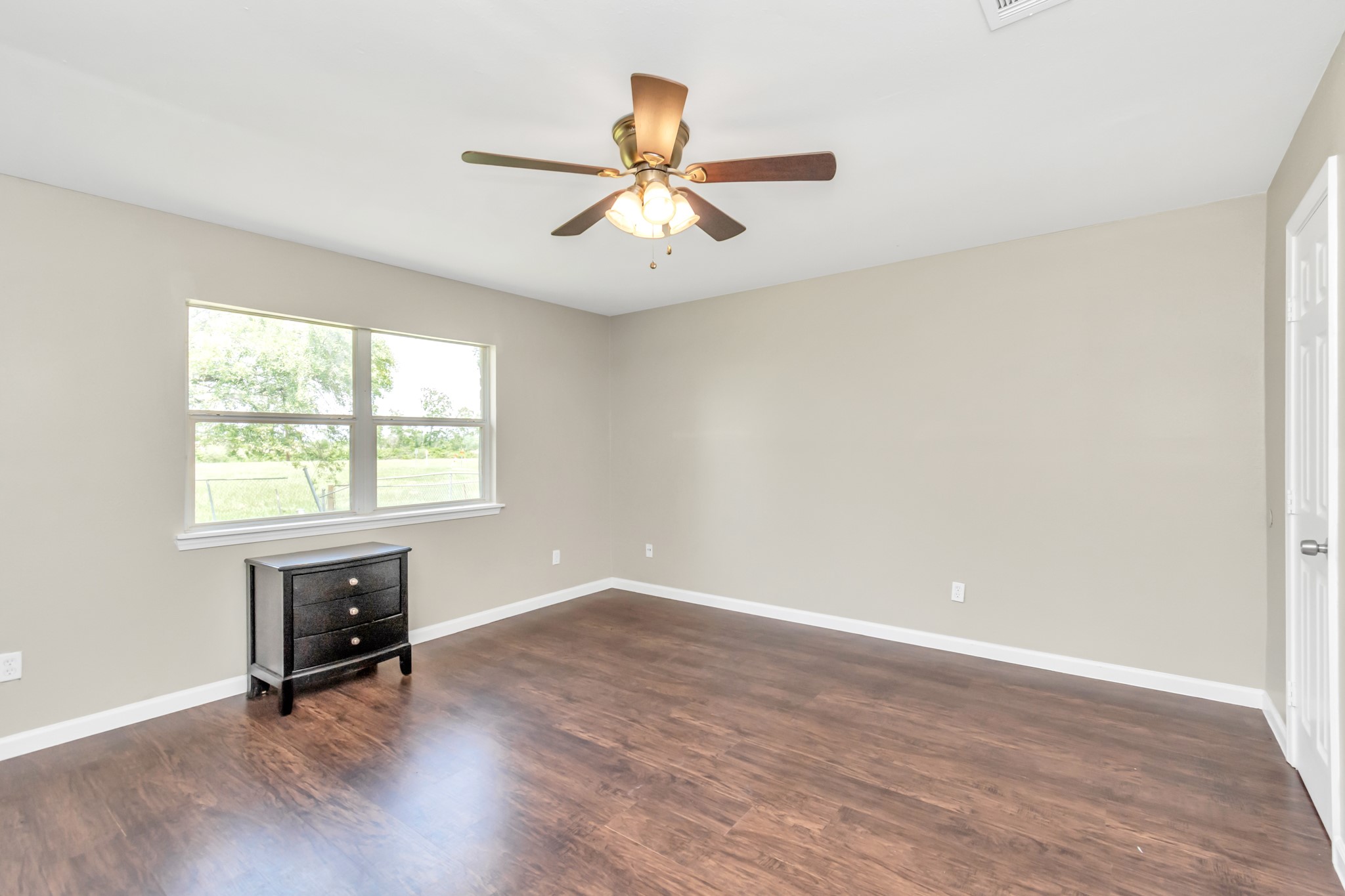 14519 Edenglen Drive Houston, TX 77049 - Photo 25 of 32 an empty room with wooden floor chandelier fan and windows