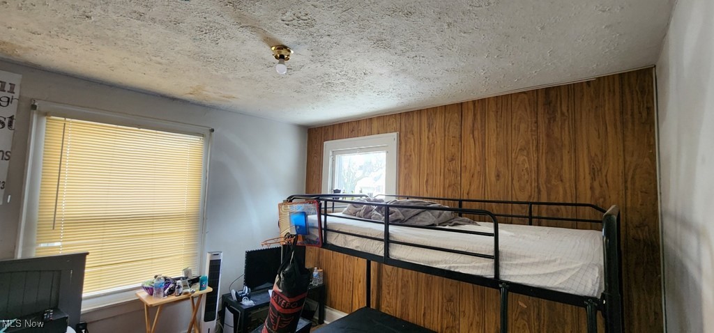 10534 Elmarge Road Cleveland, OH 44105 - Photo 5 of 9 Bedroom with wooden walls and a textured ceiling