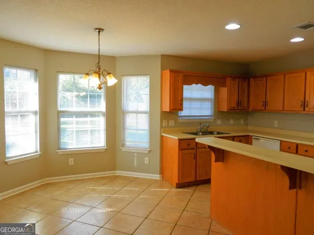 a kitchen that has a sink cabinets and window