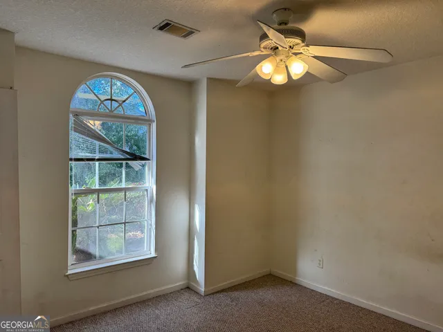 a view of a small space with a chandelier fan