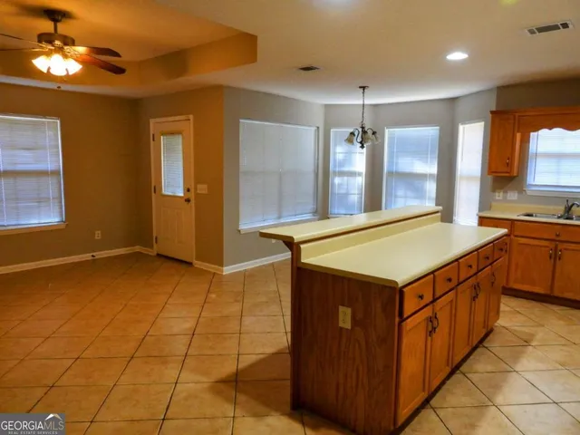 a kitchen with a stove a sink a refrigerator and cabinets