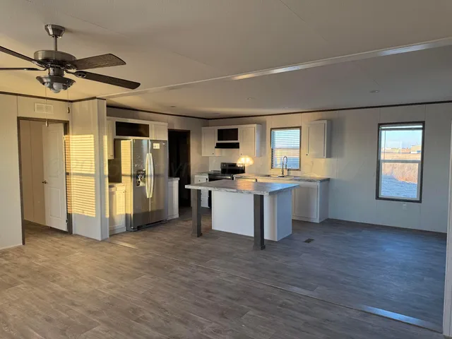 a view of kitchen with refrigerator and window