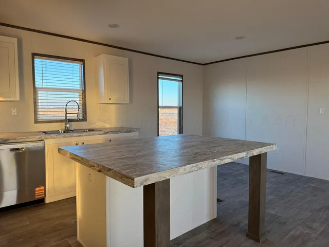 a kitchen with a sink cabinets and wooden floor