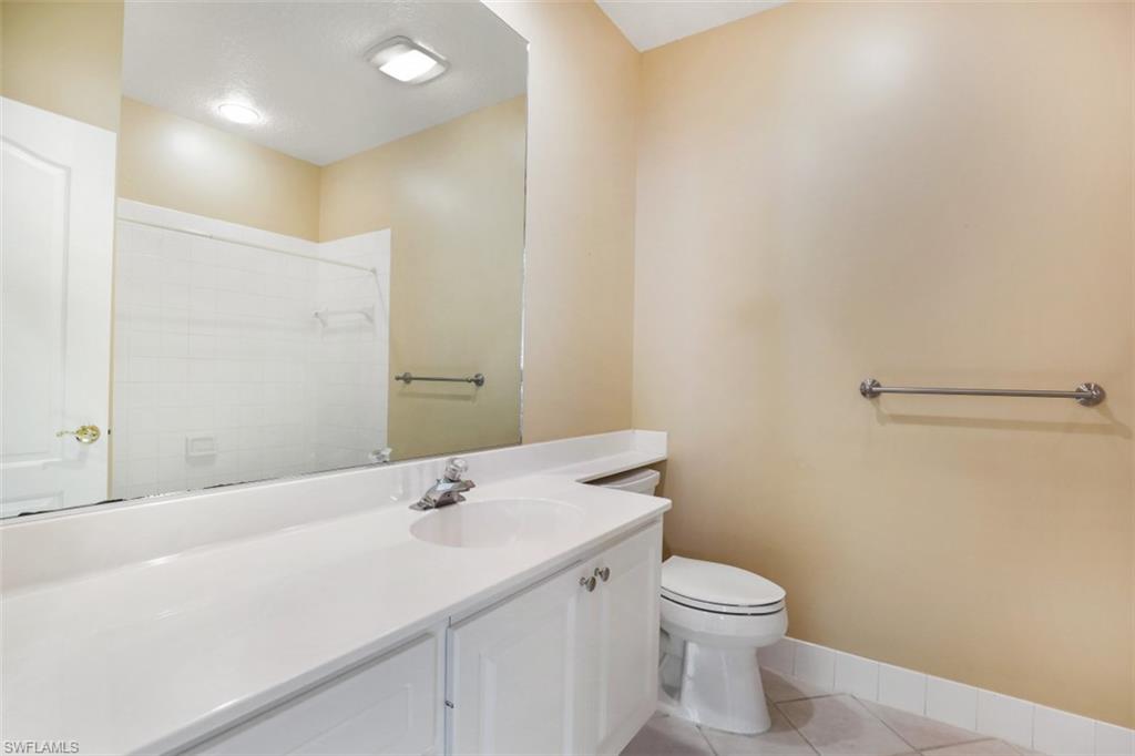 5721 Cove Circle, Unit 36 Naples, FL 34119 - Photo 15 of 32 a bathroom with a sink a toilet and a mirror