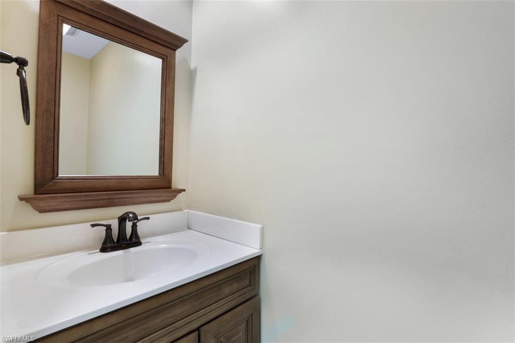 5721 Cove Circle, Unit 36 Naples, FL 34119 - Photo 17 of 32 a bathroom with a sink and a mirror