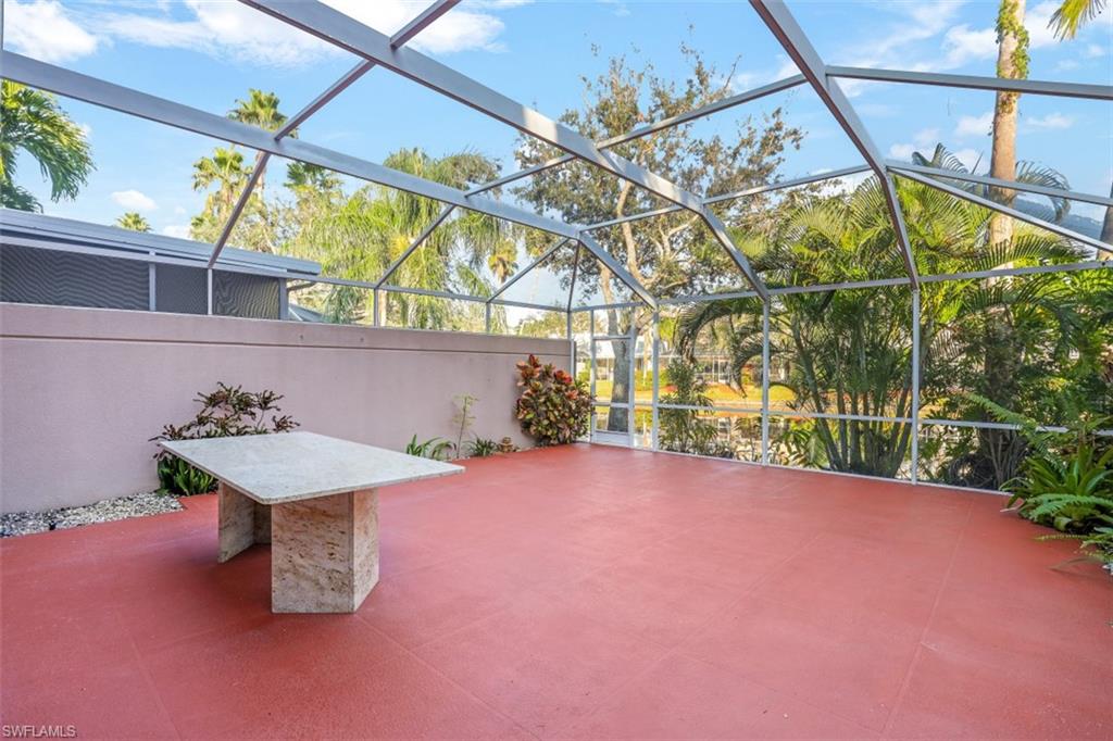 5721 Cove Circle, Unit 36 Naples, FL 34119 - Photo 22 of 32 a backyard of a house with lots of green space and glass windows