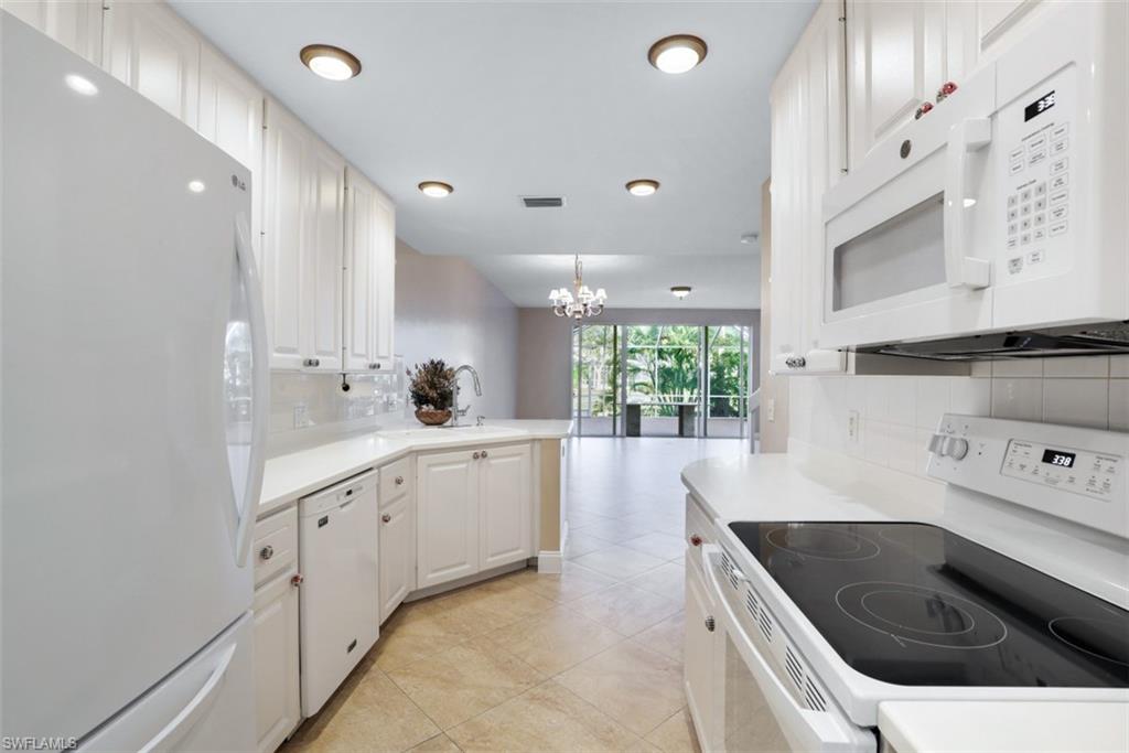 5721 Cove Circle, Unit 36 Naples, FL 34119 - Photo 8 of 32 a kitchen with white cabinets and sink
