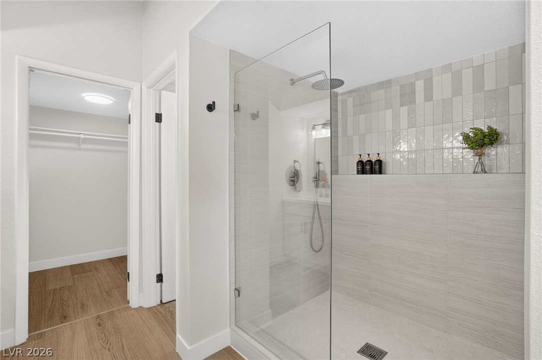2681 Rungsted Street Las Vegas, NV 89142 - Photo 20 of 33 A sleek, contemporary bathroom with a spacious glass-enclosed shower and wood-look flooring.