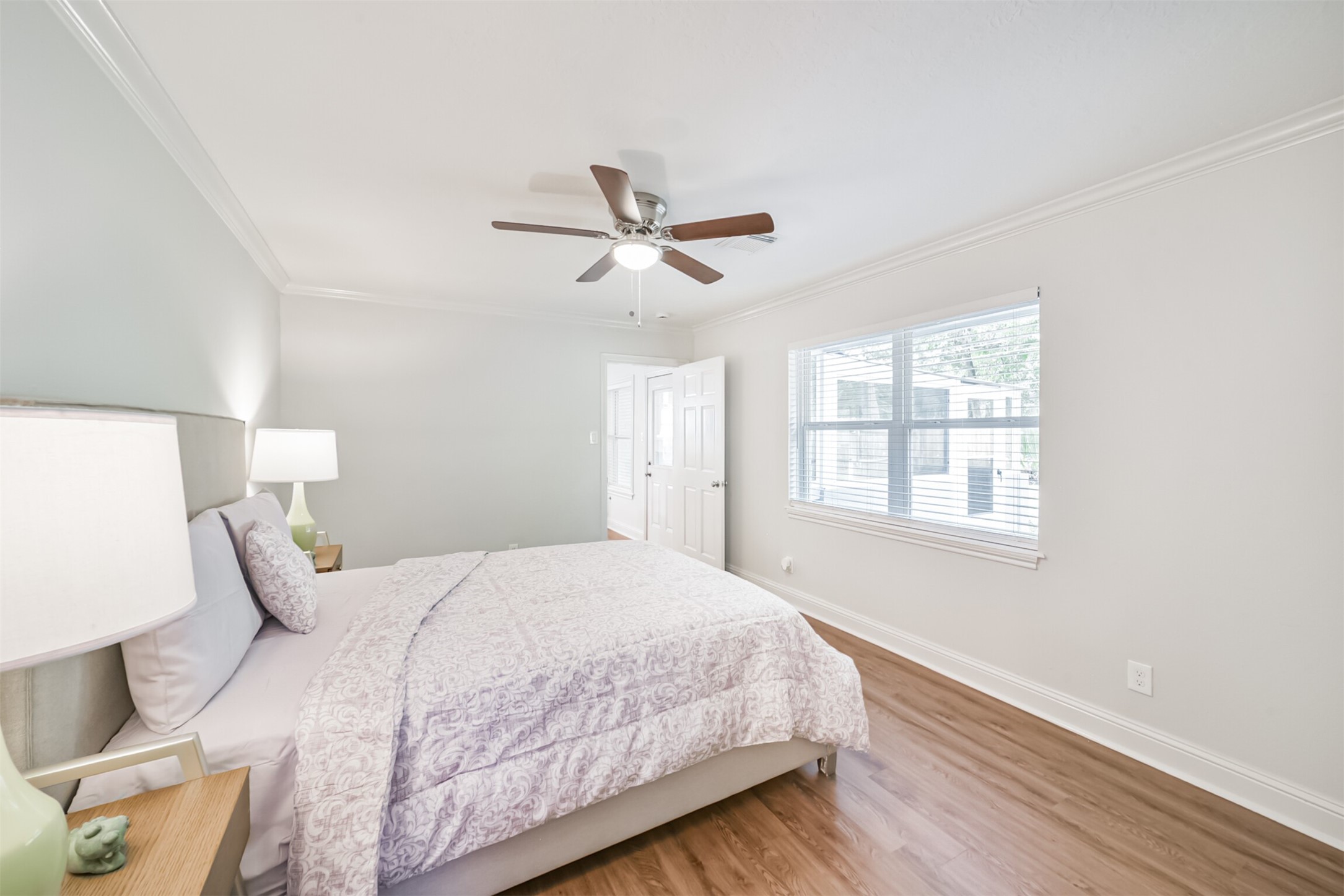 3319 Springrock Lane Houston, TX 77080 - Photo 21 of 41 a bedroom with a large bed chandelier and a window