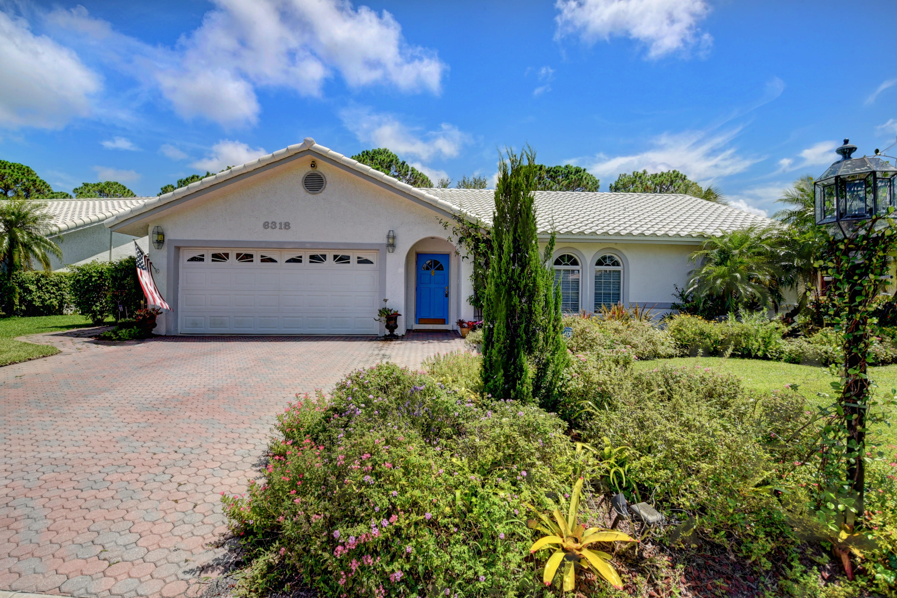 6318 Woodbury Road Boca Raton, FL 33433 - Photo 1 of 52 a view of a house with a yard and potted plants