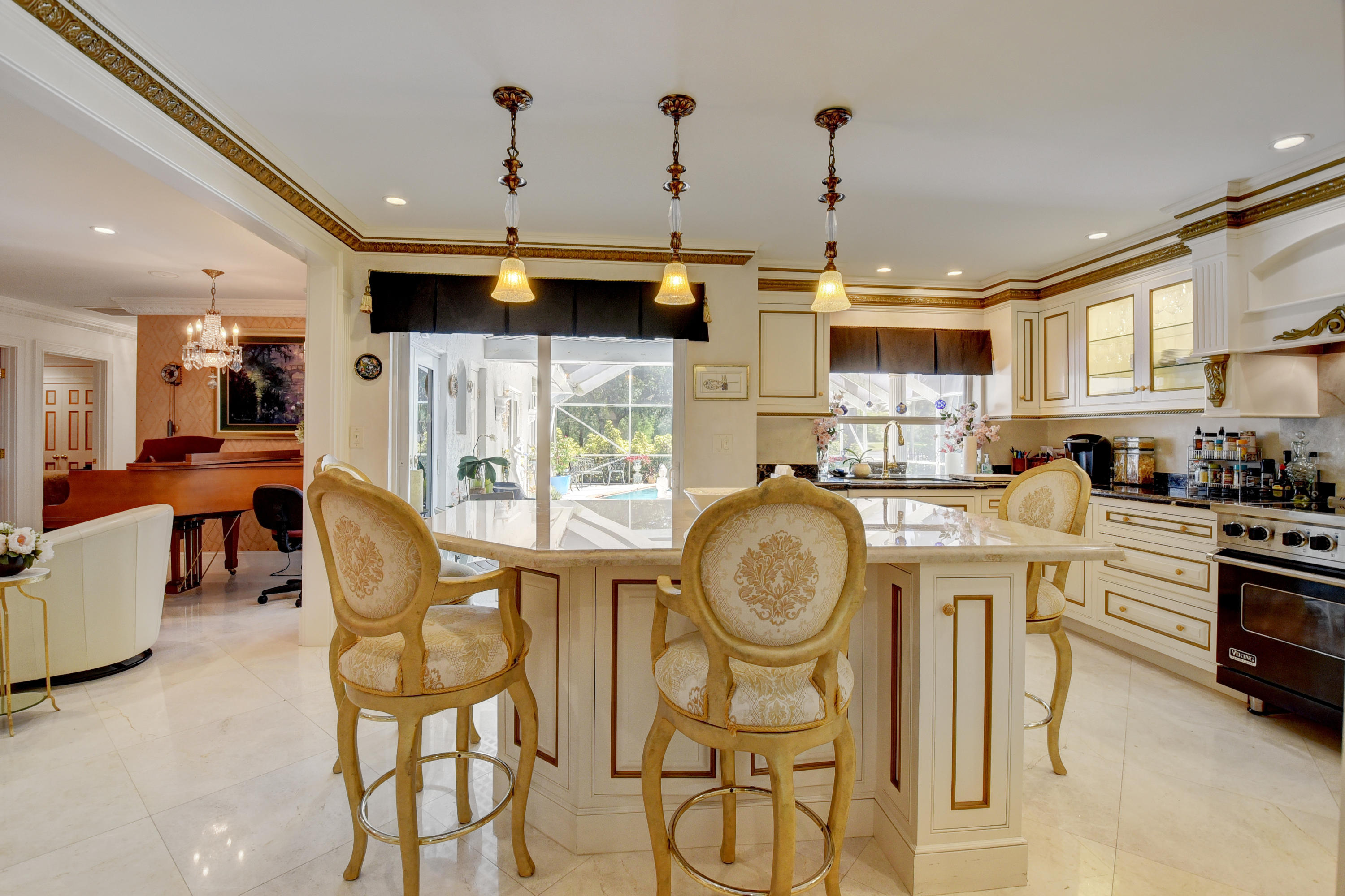 6318 Woodbury Road Boca Raton, FL 33433 - Photo 14 of 52 a kitchen with stainless steel appliances kitchen island granite countertop a table chairs and a refrigerator