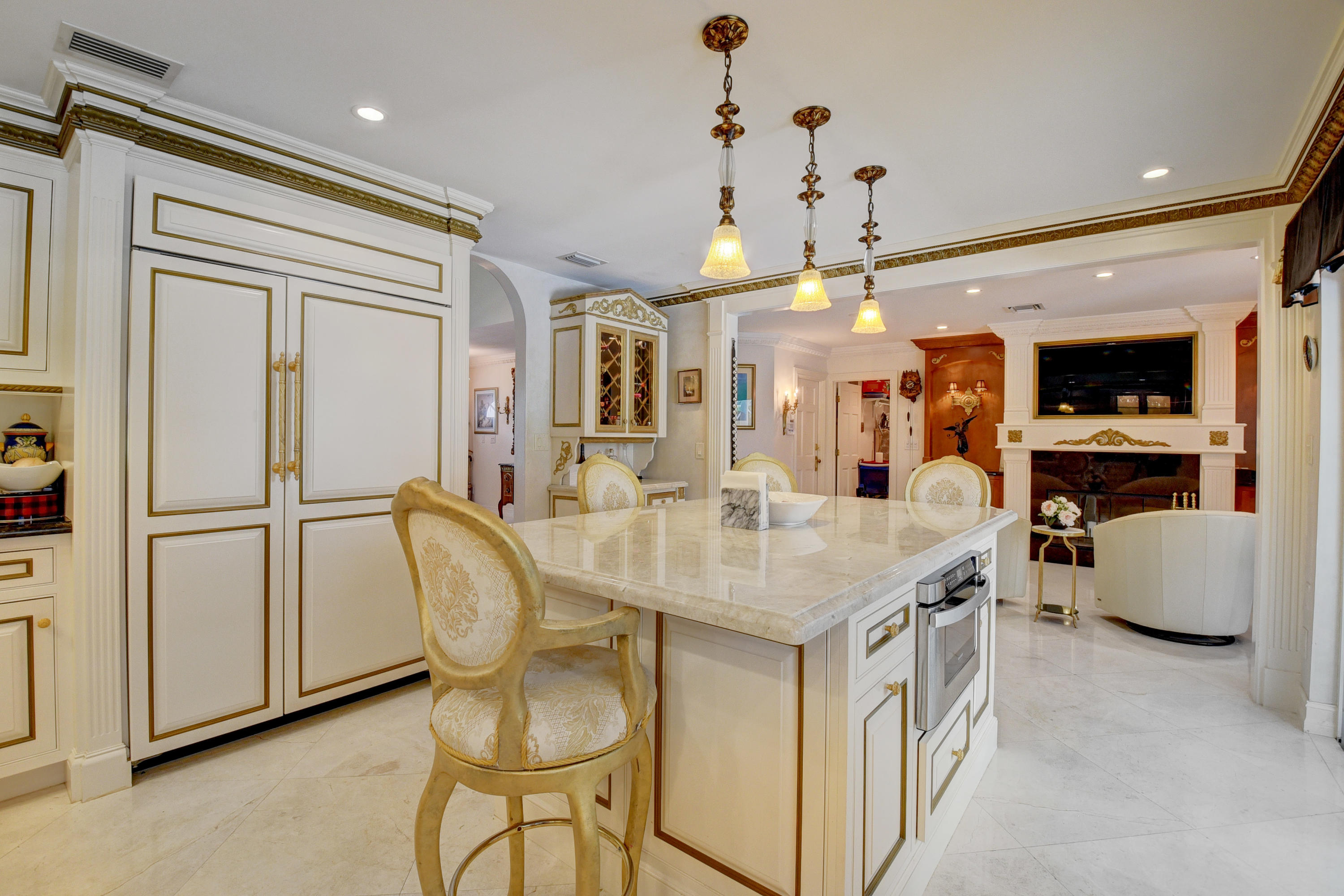 6318 Woodbury Road Boca Raton, FL 33433 - Photo 16 of 52 a kitchen with stainless steel appliances granite countertop a dining table chairs and a refrigerator
