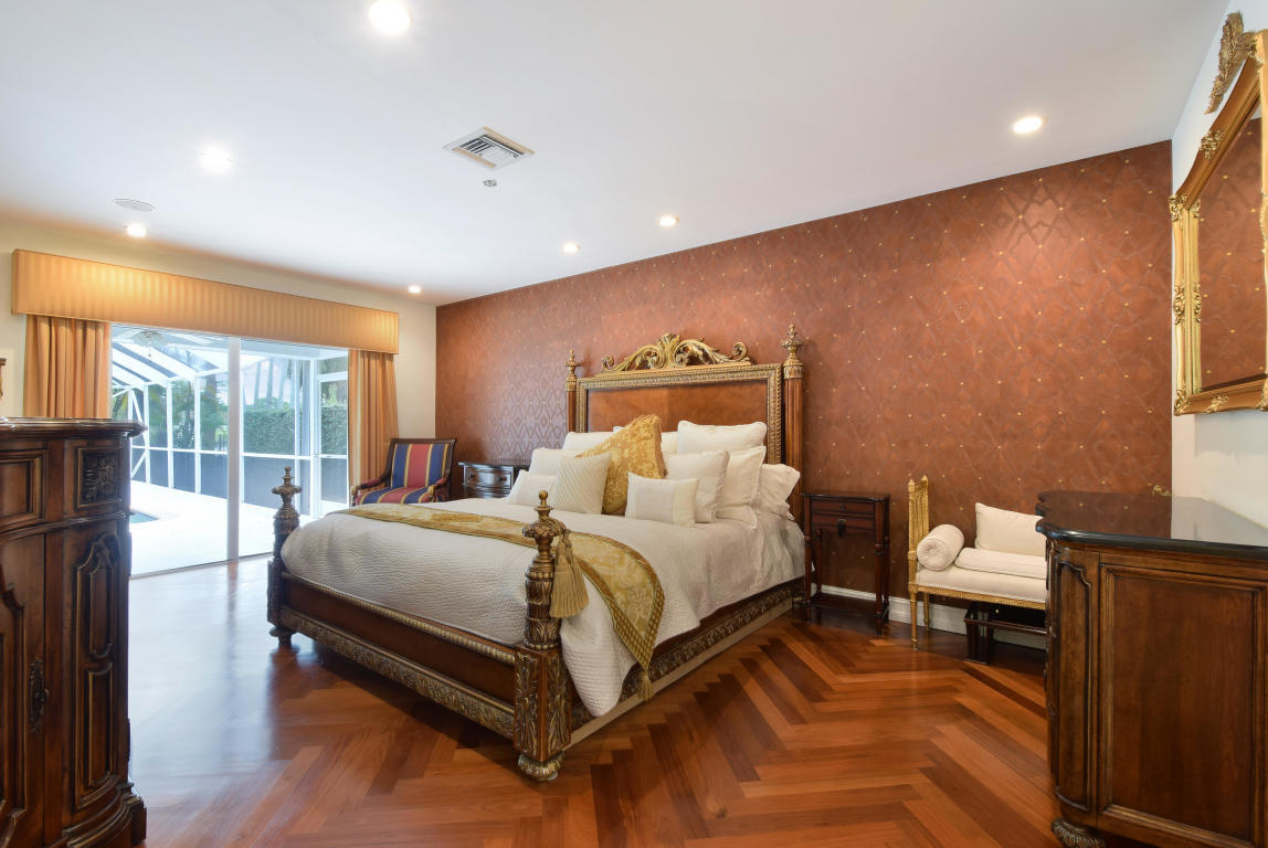 6318 Woodbury Road Boca Raton, FL 33433 - Photo 19 of 52 a bedroom with a bed and wooden floor