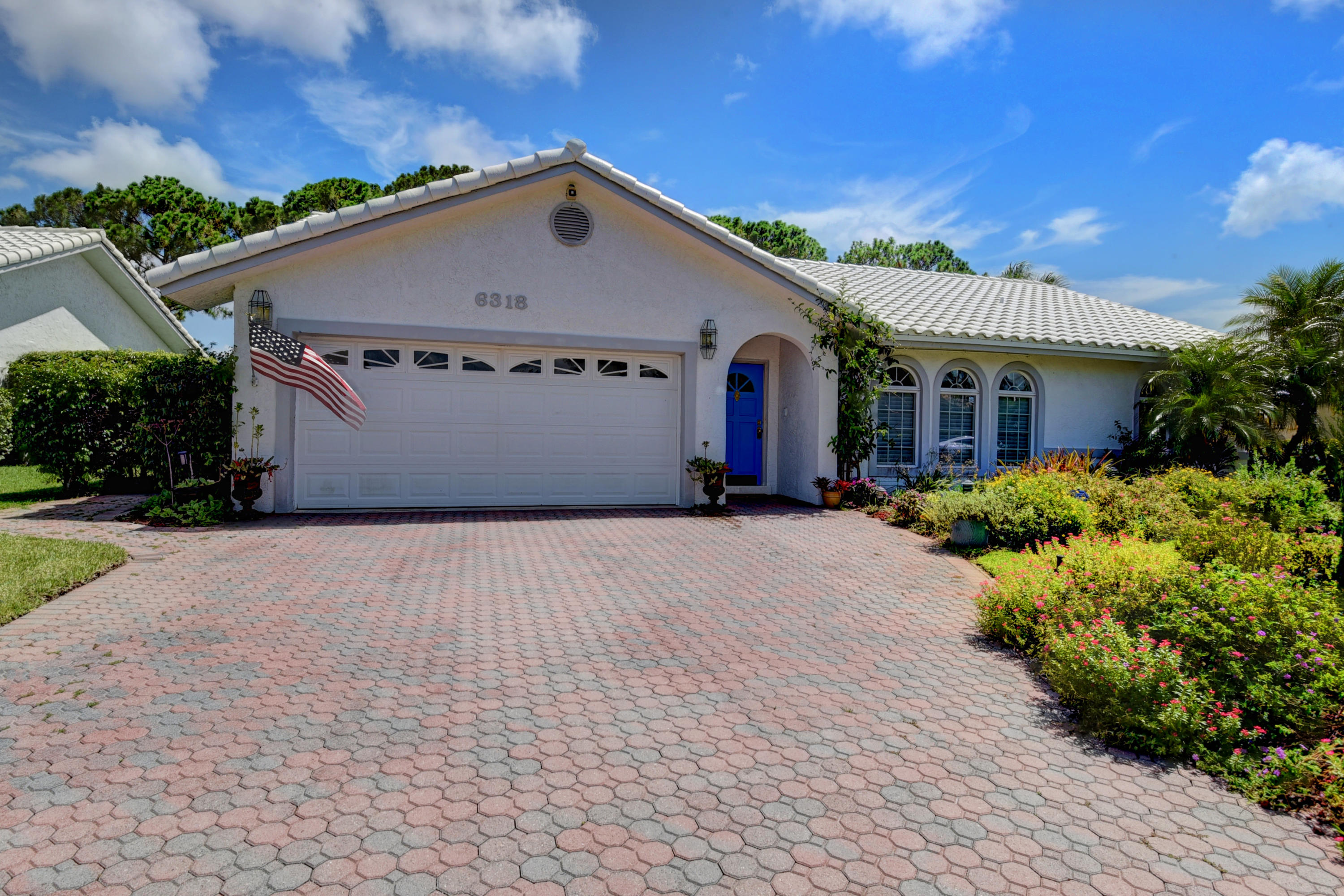 6318 Woodbury Road Boca Raton, FL 33433 - Photo 2 of 52 a front view of a house with a yard