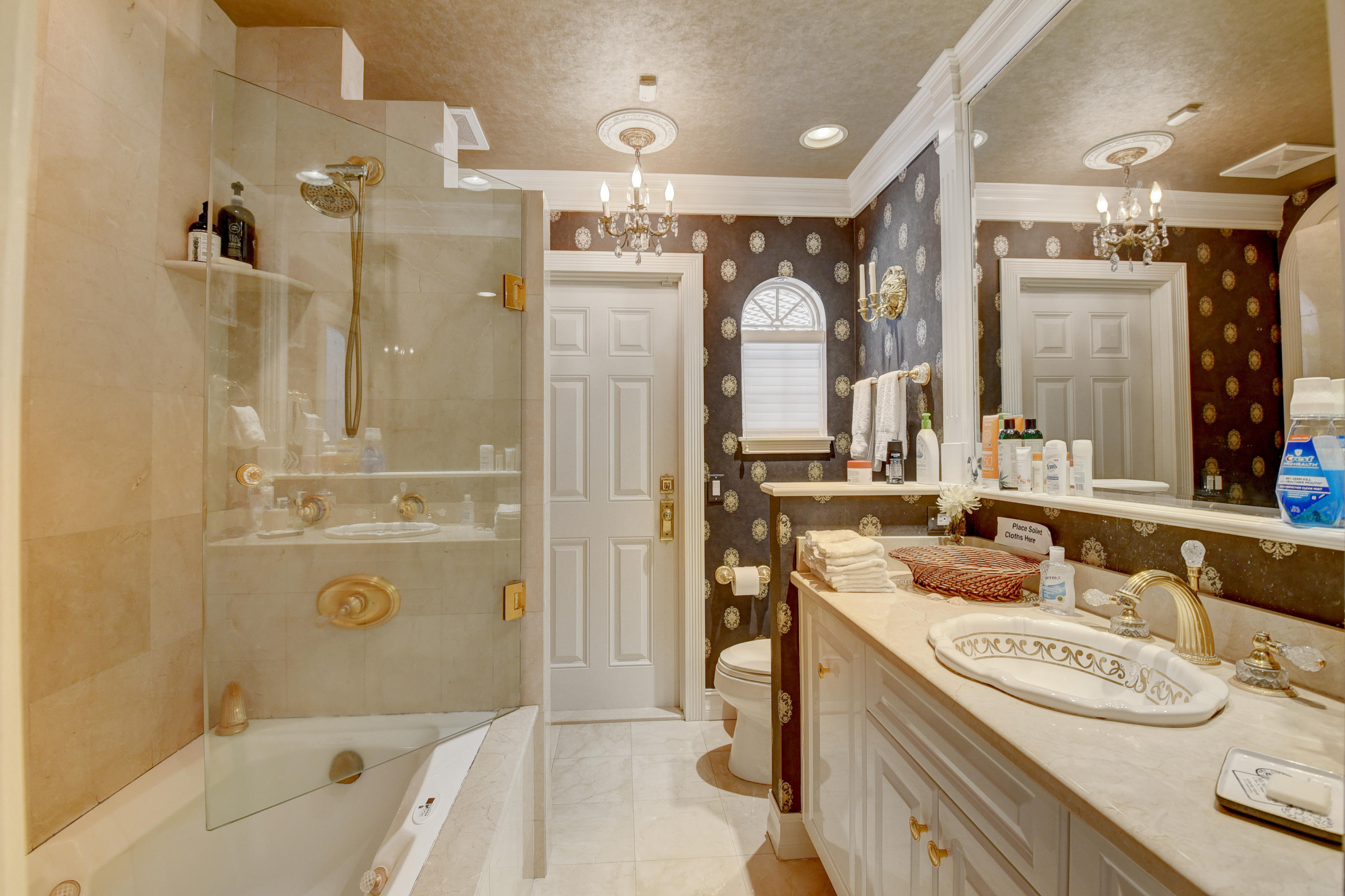6318 Woodbury Road Boca Raton, FL 33433 - Photo 30 of 52 a bathroom with a tub a sink a mirror and a shower