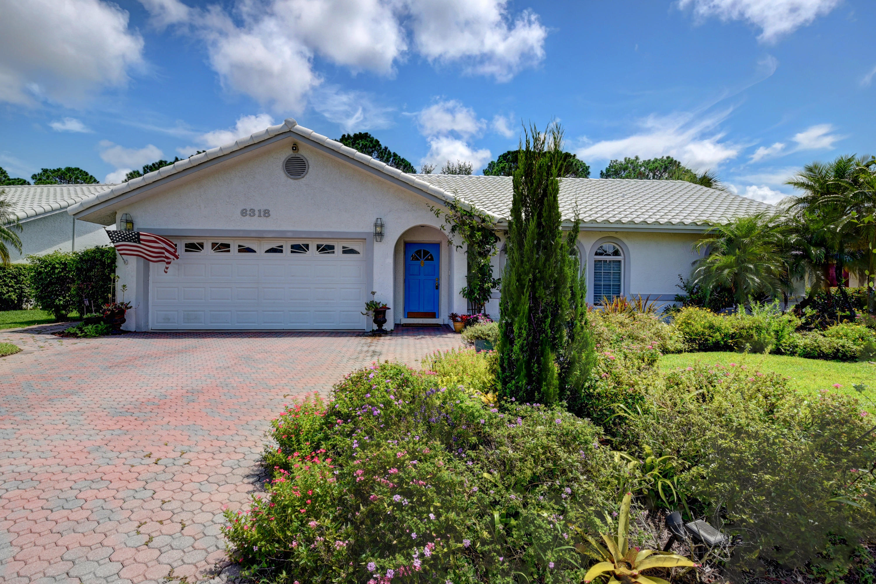 6318 Woodbury Road Boca Raton, FL 33433 - Photo 3 of 52 a view of garage with a garden