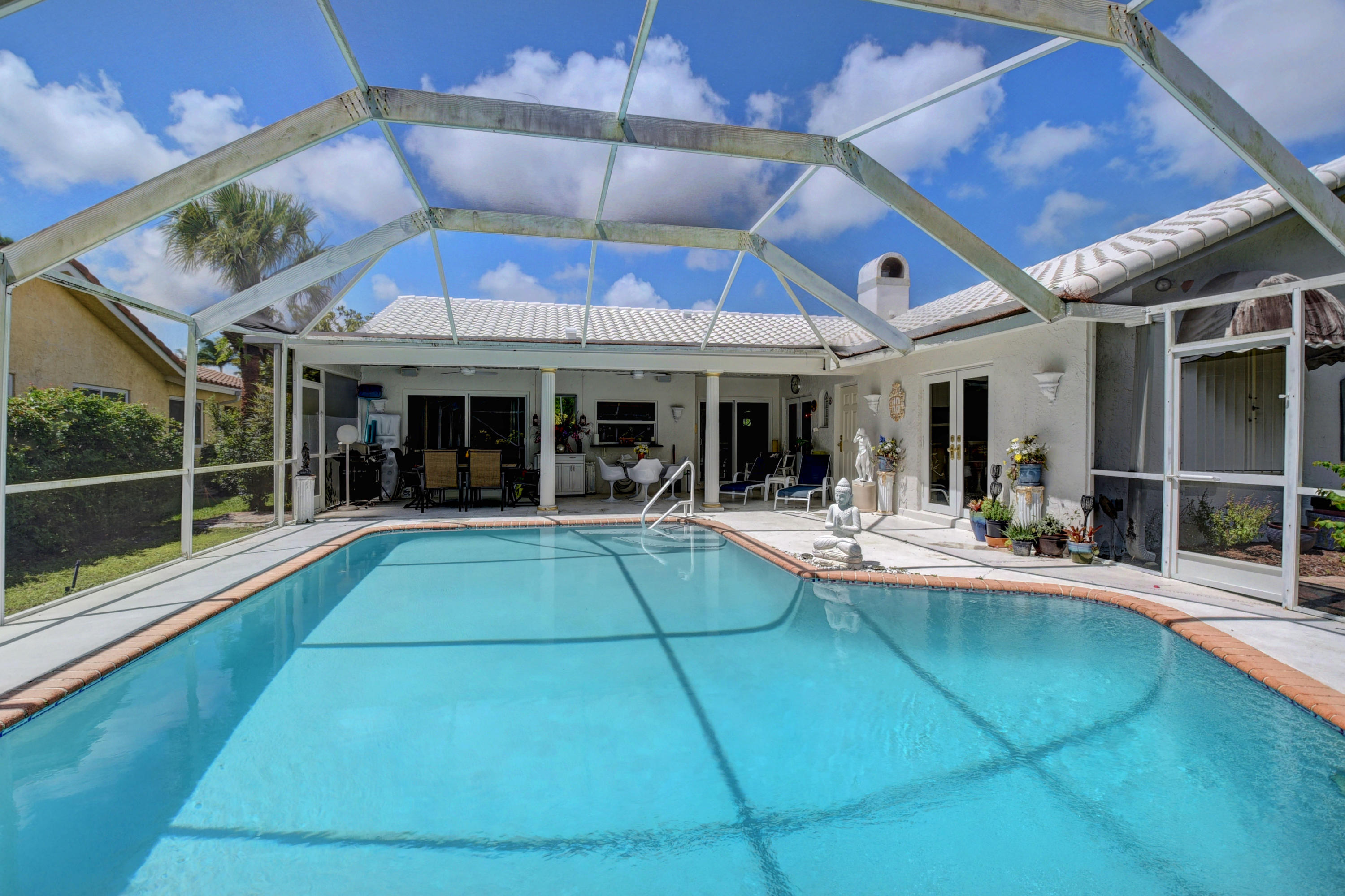 6318 Woodbury Road Boca Raton, FL 33433 - Photo 34 of 52 a view of a patio with table and chairs under an umbrella