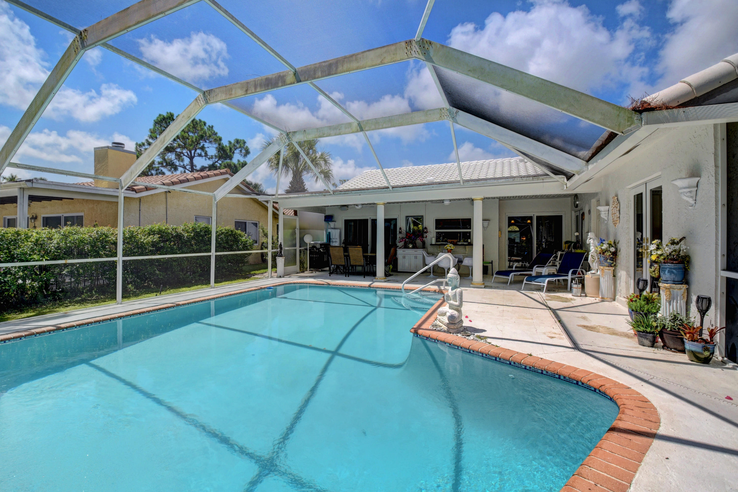 6318 Woodbury Road Boca Raton, FL 33433 - Photo 35 of 52 a view of a patio with a table and chairs under an umbrella
