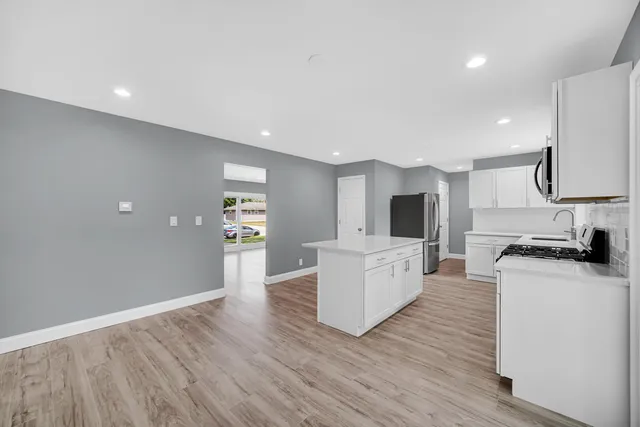 a living room with furniture a flat screen tv and a wooden floor