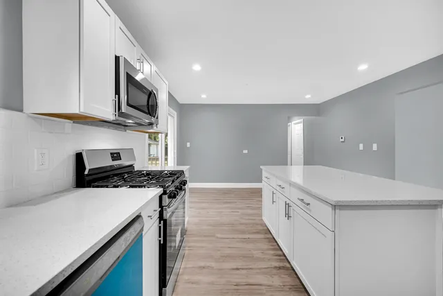 a kitchen with stainless steel appliances a stove a sink and a refrigerator