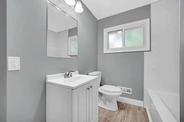 a bathroom with a sink toilet and a mirror