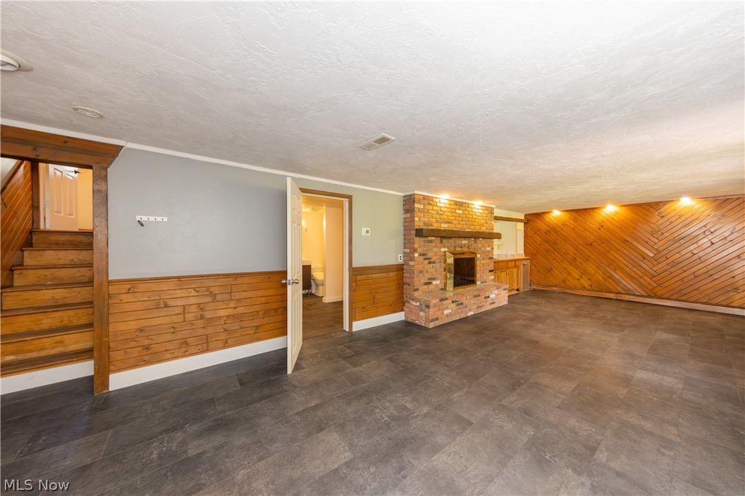 7969 Dines Road Novelty, OH 44072 - Photo 34 of 48 Spacious family room featuring dark tile-finish flooring, a brick fireplace with a wood mantel, and wood paneling