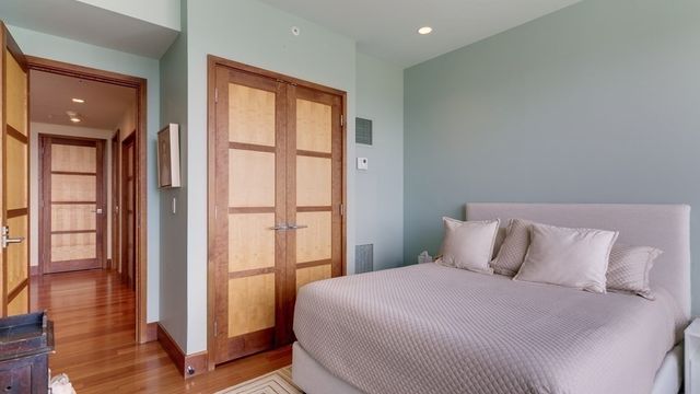 a bedroom with a bed and wooden floor