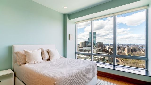 a bedroom with a large window and a bed